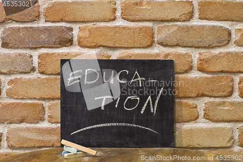 Image of Chalk board with the word EDUCATION drown by hand and chalks on 
