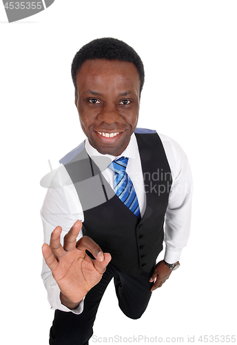 Image of African man kneeling making OK sign