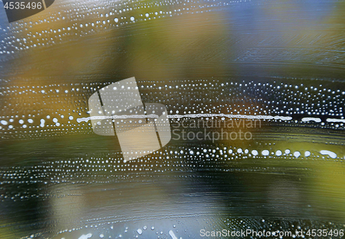 Image of Bright color texture with soap foam pattern on glass