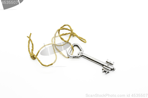 Image of Old silver key on a rough rope on white background