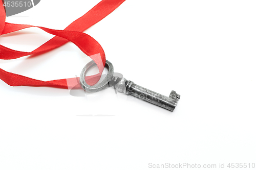 Image of Vintage silver key with red ribbon on white background