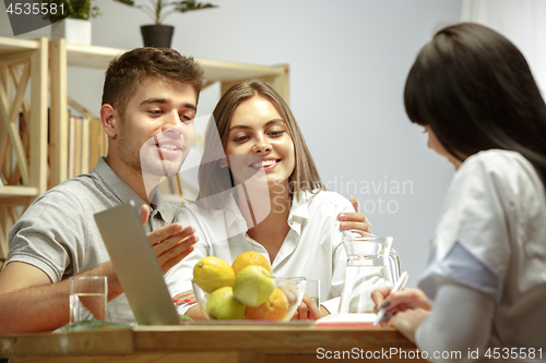 Image of Smiling nutritionist showing a healthy diet plan to patient