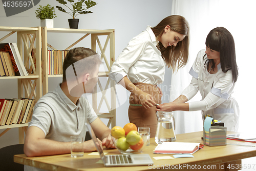 Image of Smiling nutritionist showing a healthy diet plan to patient