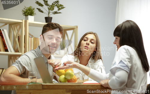 Image of Smiling nutritionist showing a healthy diet plan to patient