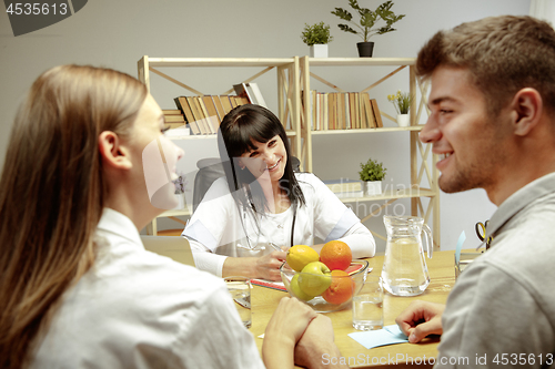 Image of Smiling nutritionist showing a healthy diet plan to patient