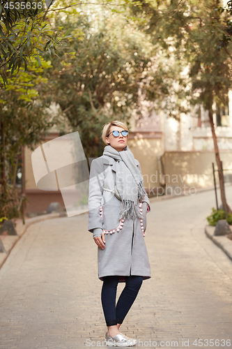 Image of Young blond woman with sunglases on the street