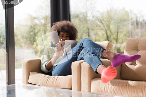 Image of young african american woman at home using digital tablet
