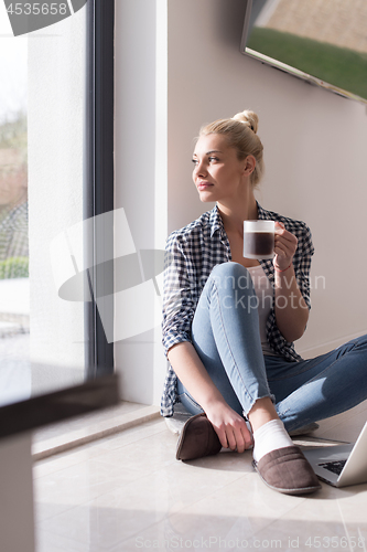 Image of young woman drinking coffee enjoying relaxing lifestyle