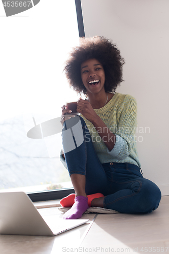 Image of black woman in the living room on the floor