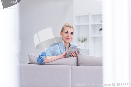 Image of woman on sofa using tablet computer