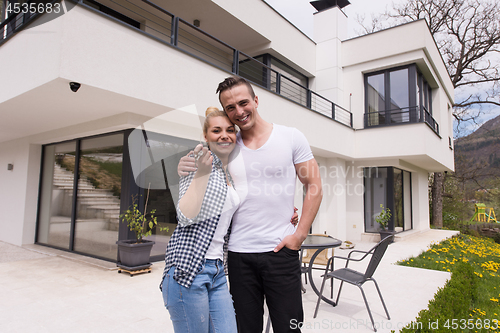 Image of couple hugging in front of  new luxury home