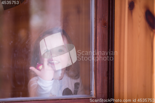 Image of little cute girl playing near the window