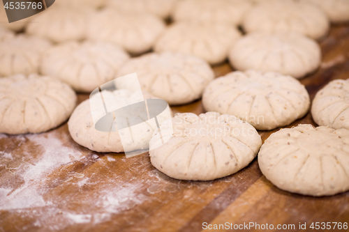 Image of balls of dough bread getting ready to be baked