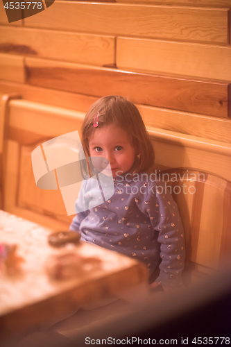 Image of little cute girl playing near the window