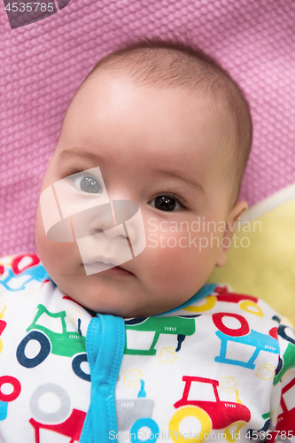 Image of top view of newborn baby boy lying on colorful blankets