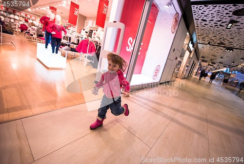 Image of little girl running through shopping mall