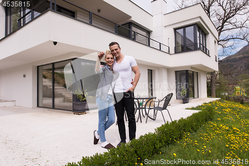 Image of couple hugging in front of  new luxury home