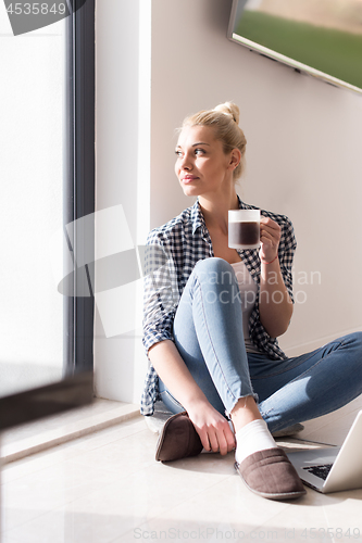 Image of young woman drinking coffee enjoying relaxing lifestyle