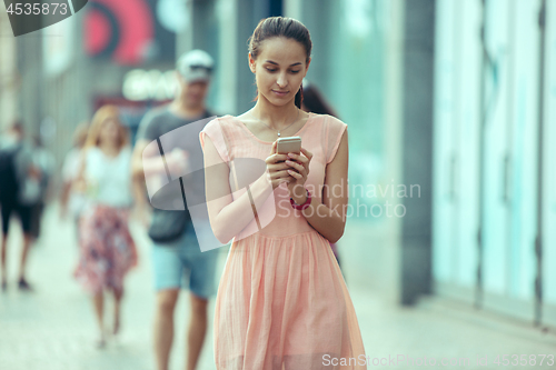 Image of Young Beautiful Woman Talking On Mobile Phone Outdoor.