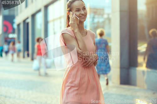 Image of Young Beautiful Woman Talking On Mobile Phone Outdoor.