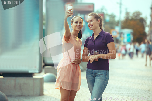 Image of Young Beautiful Women Talking On Mobile Phone Outdoor.