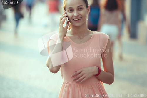 Image of Young Beautiful Woman Talking On Mobile Phone Outdoor.