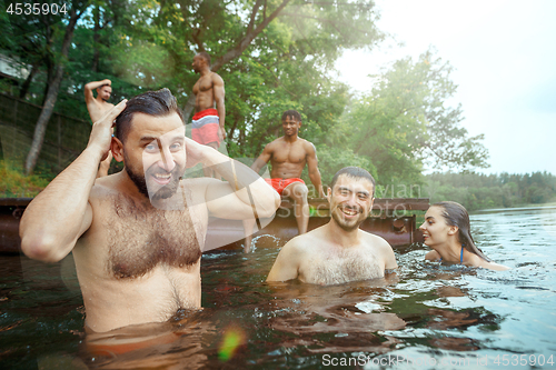 Image of Enjoying river party with friends. Group of beautiful happy young people at the river together