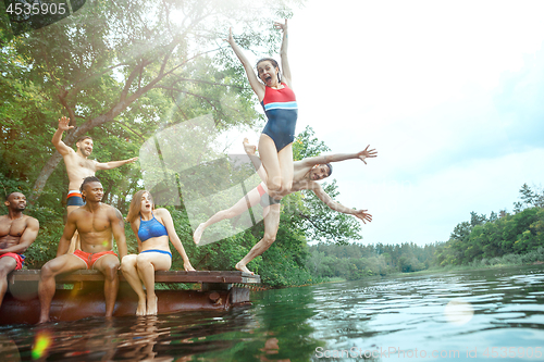 Image of Enjoying river party with friends. Group of beautiful happy young people at the river together