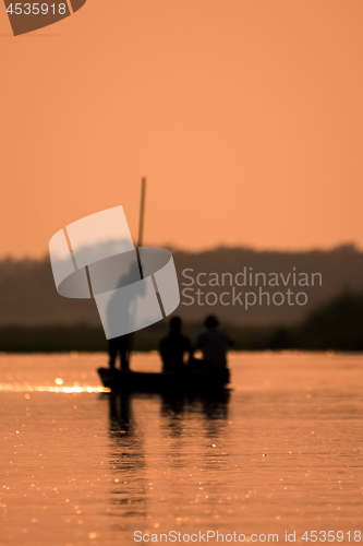 Image of Blurred Men in a boat on a river silhouette