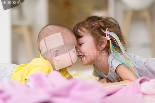 Image of little sister and her baby brother playing at home