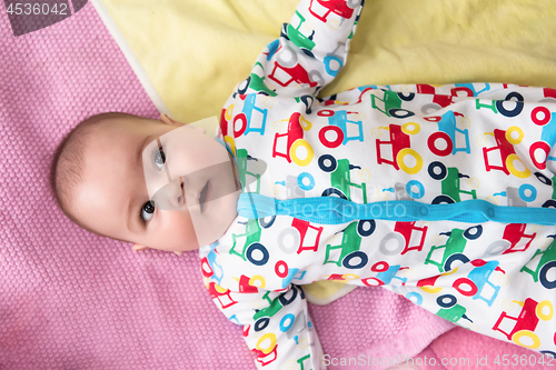 Image of top view of newborn baby boy lying on colorful blankets