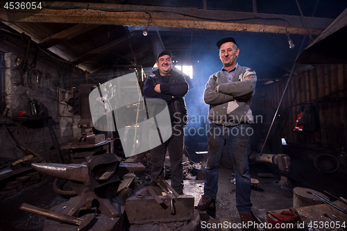 Image of portrait of two generations confident blacksmith