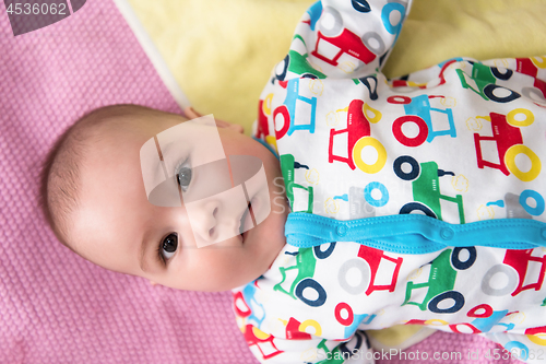 Image of top view of newborn baby boy lying on colorful blankets