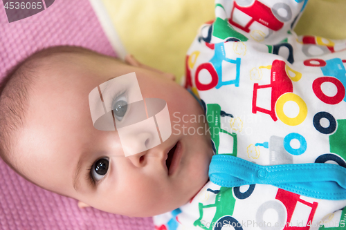 Image of top view of newborn baby boy lying on colorful blankets