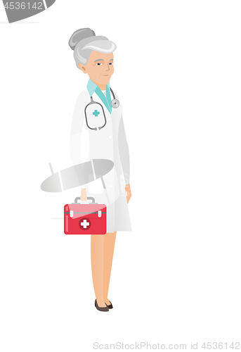 Image of Senior caucasian doctor holding first aid box.