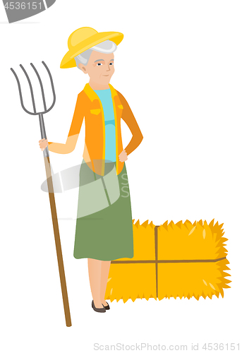 Image of Senior caucasian farmer holding a pitchfork.