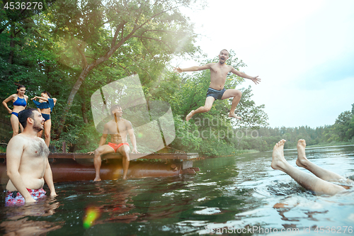 Image of Enjoying river party with friends. Group of beautiful happy young people at the river together