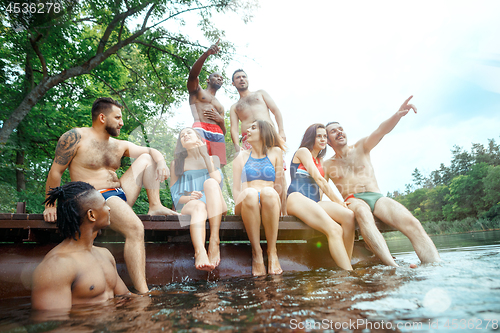 Image of Enjoying river party with friends. Group of beautiful happy young people at the river together