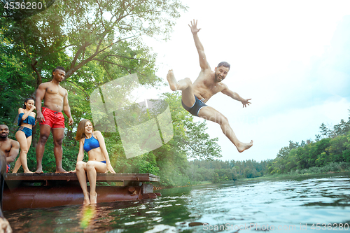 Image of Enjoying river party with friends. Group of beautiful happy young people at the river together