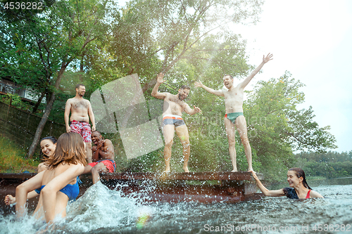 Image of Enjoying river party with friends. Group of beautiful happy young people at the river together