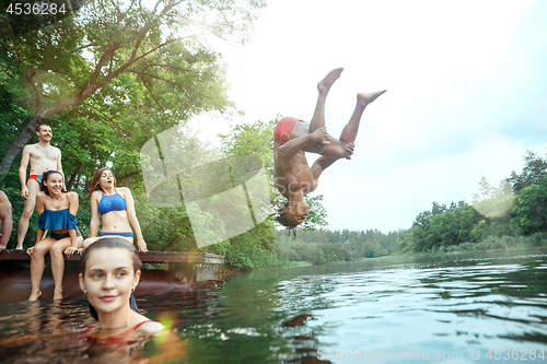 Image of Enjoying river party with friends. Group of beautiful happy young people at the river together