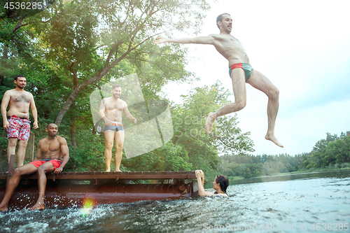 Image of Enjoying river party with friends. Group of beautiful happy young people at the river together