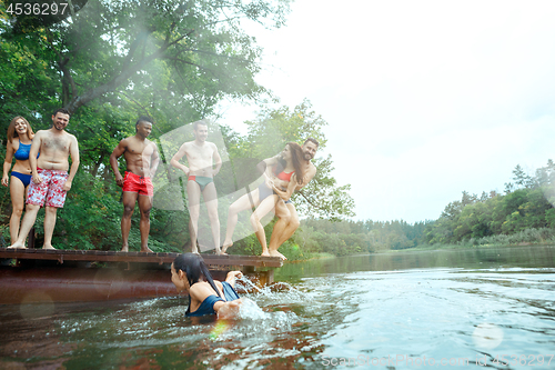 Image of Enjoying river party with friends. Group of beautiful happy young people at the river together