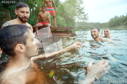 Image of Enjoying river party with friends. Group of beautiful happy young people at the river together