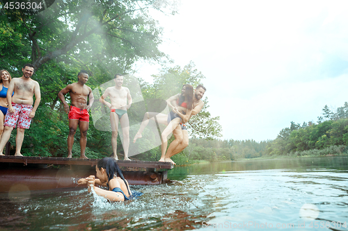 Image of Enjoying river party with friends. Group of beautiful happy young people at the river together