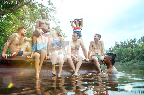 Image of Enjoying river party with friends. Group of beautiful happy young people at the river together