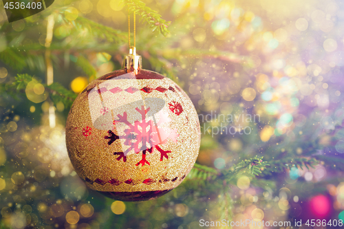 Image of Christmas-tree decoration bauble on decorated Christmas tree bac