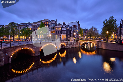 Image of Amterdam canal, bridge and medieval houses in the evening