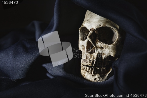 Image of Closeup photo an old skull covered in black robe