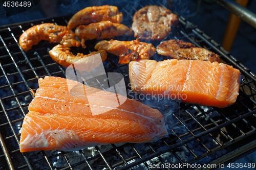Image of Salmon stake frying outside on the fire